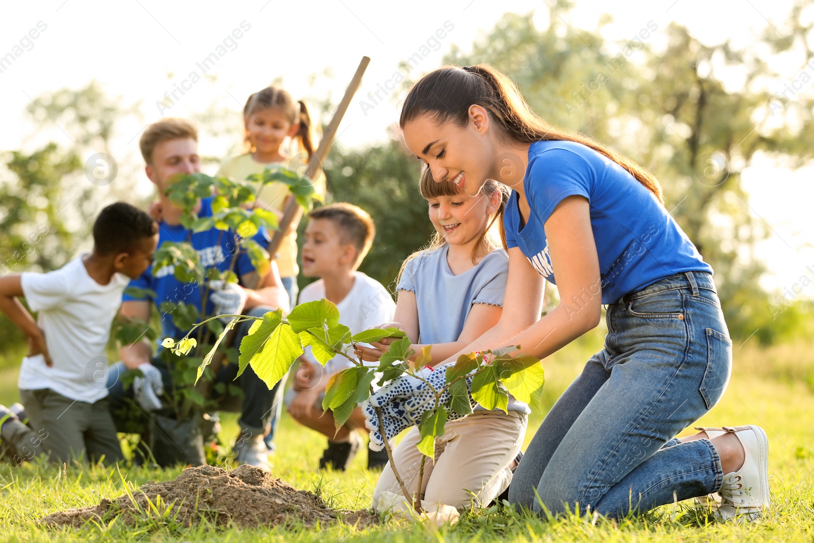 Photo of Kids planting trees with volunteers in park