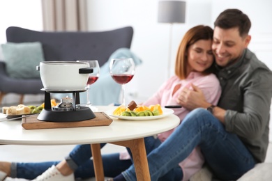 Happy couple enjoying fondue dinner at home