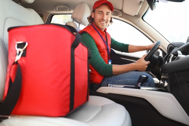 Male courier with thermo bag in car. Food delivery service