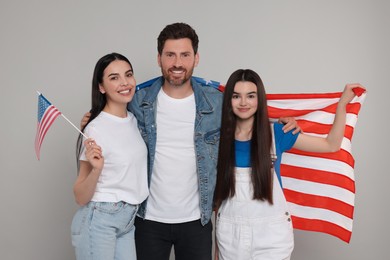 4th of July - Independence Day of USA. Happy family with American flags on grey background