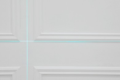 Cross lines of laser level on white wall