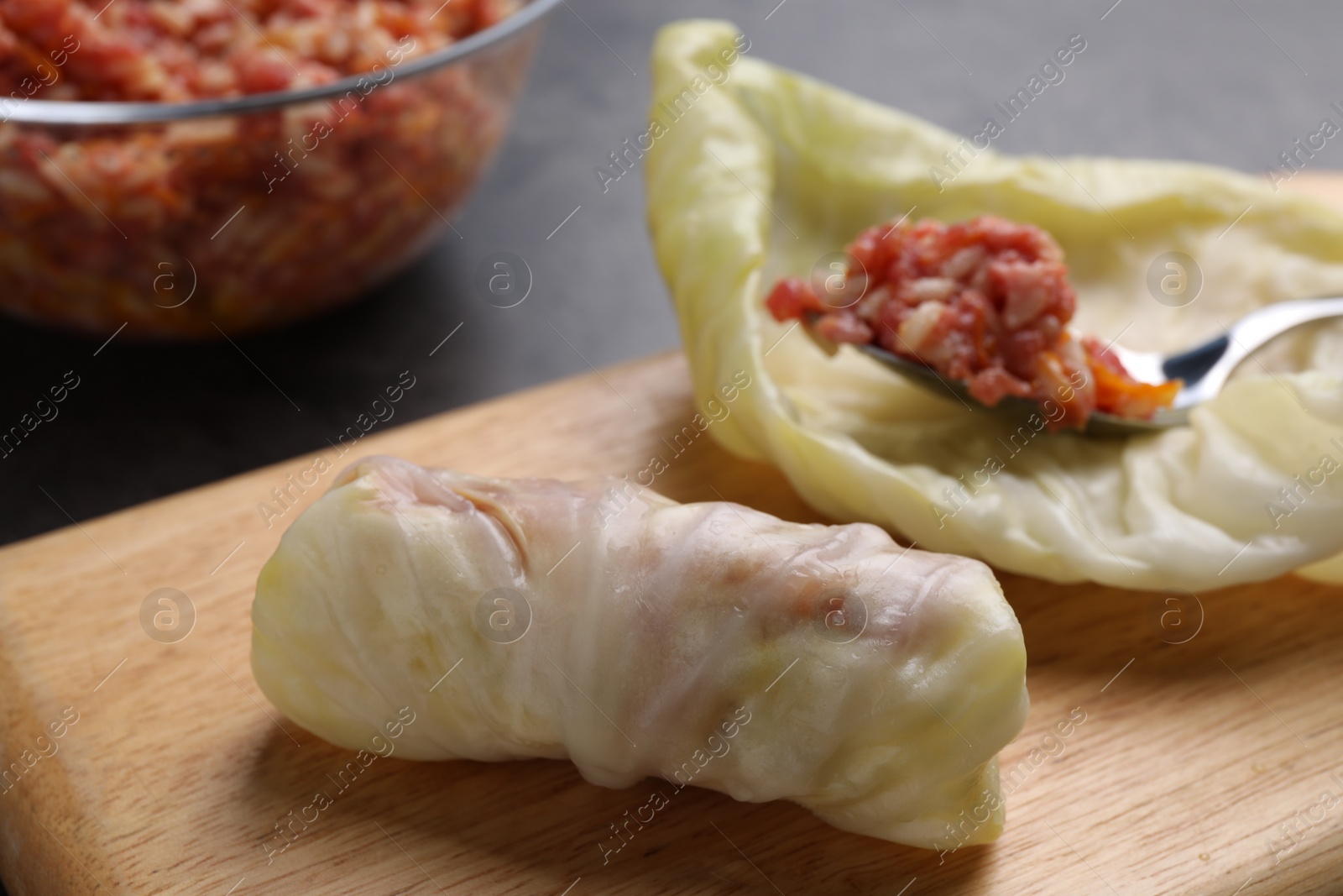 Photo of Preparing stuffed cabbage rolls on table, closeup