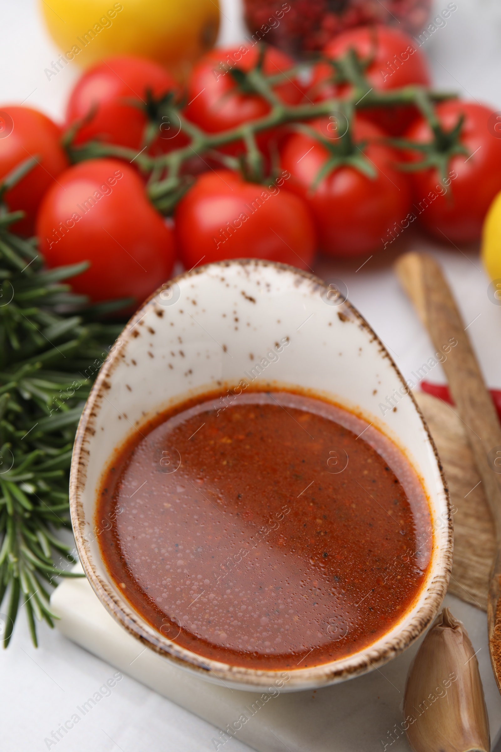 Photo of Fresh marinade and different ingredients on white table, closeup