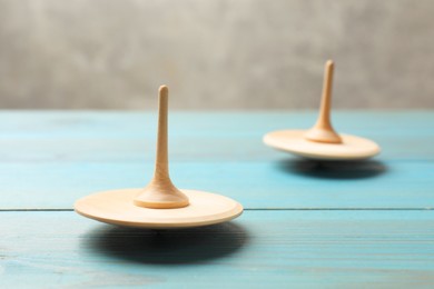 Spinning tops on light blue wooden table, closeup