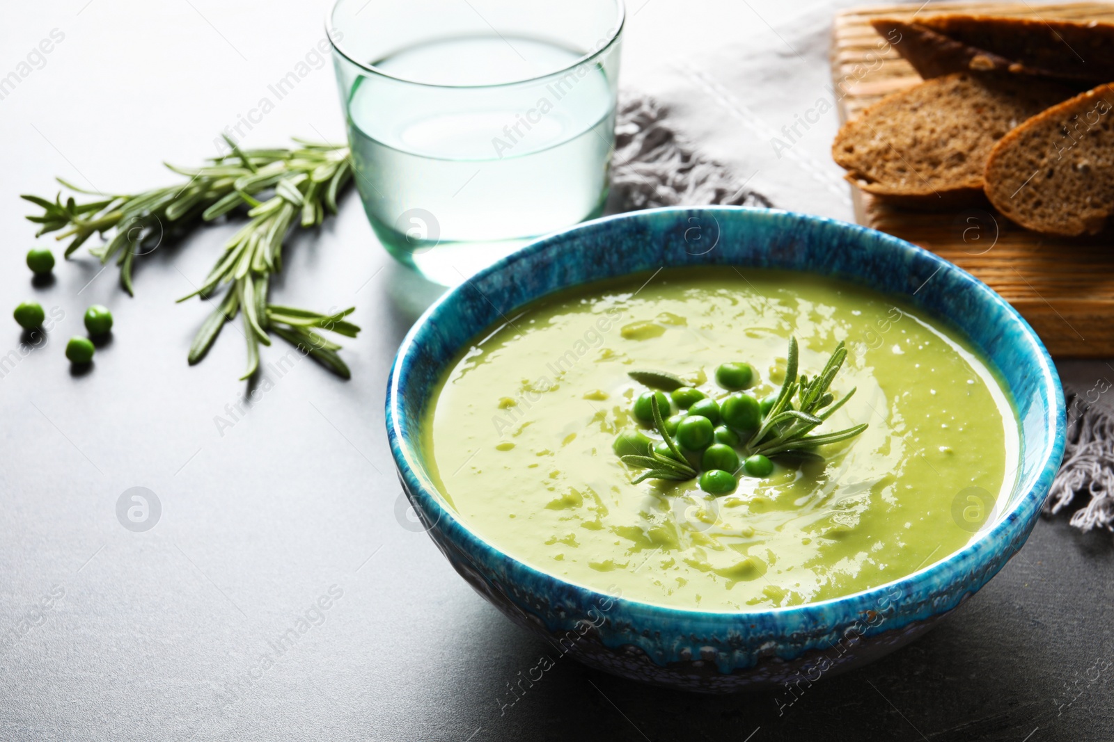 Photo of Fresh vegetable detox soup made of green peas in dish served on table. Space for text