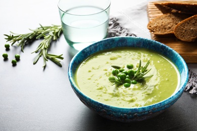 Photo of Fresh vegetable detox soup made of green peas in dish served on table. Space for text