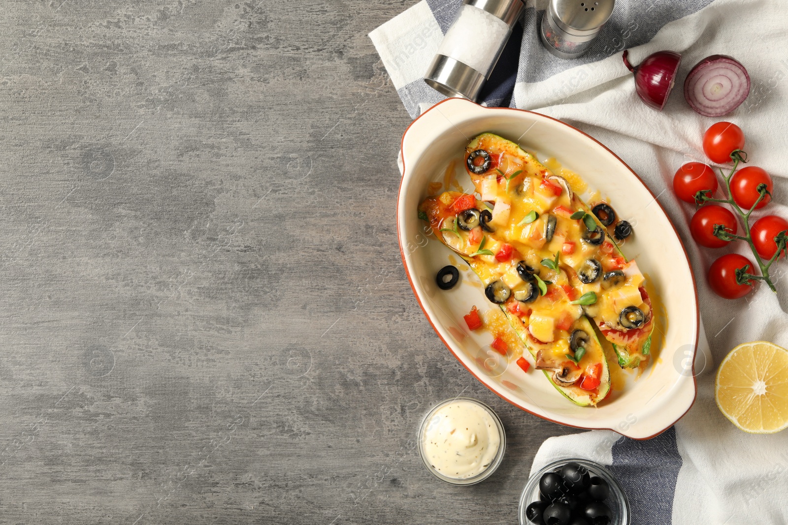 Photo of Flat lay composition with baked stuffed zucchinis on grey table, space for text