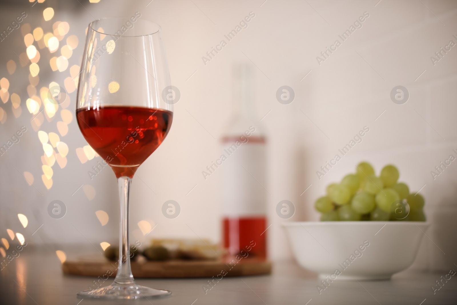 Photo of Glass of delicious wine on table, space for text. Bokeh effect