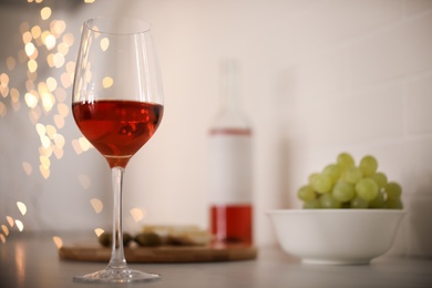 Photo of Glass of delicious wine on table, space for text. Bokeh effect