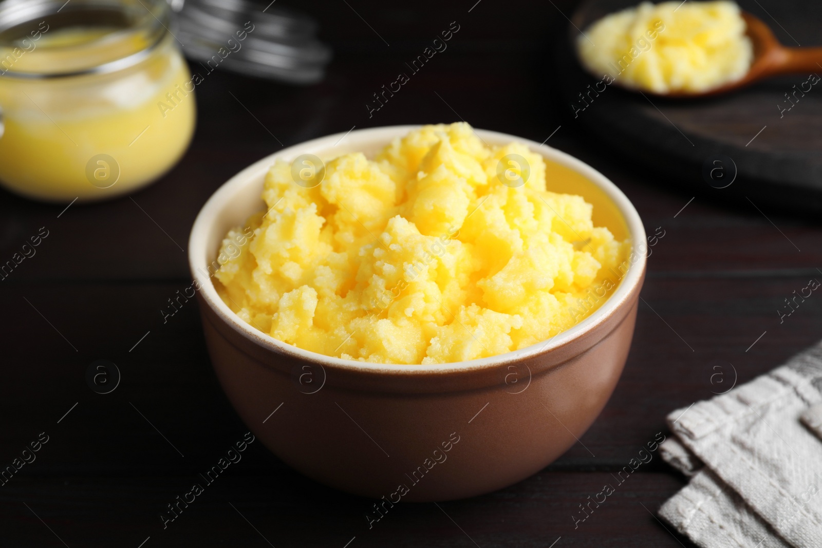 Photo of Bowl of Ghee butter on wooden table, closeup