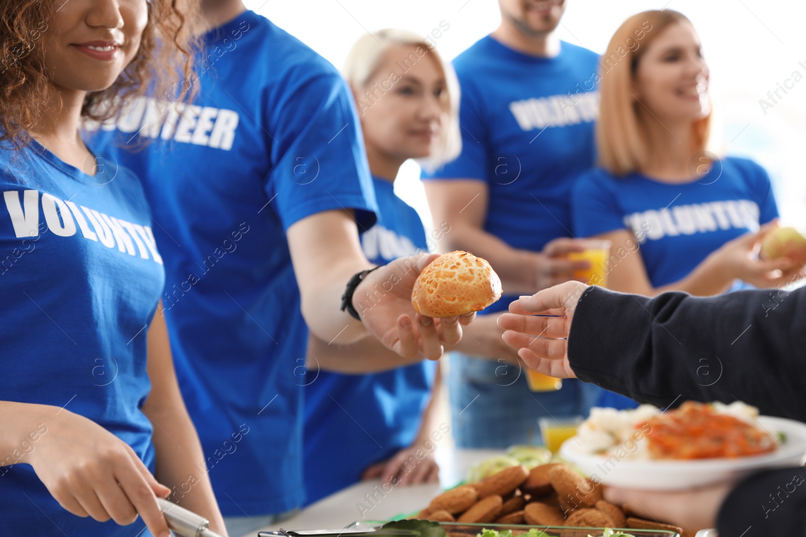 Photo of Volunteers serving food to poor people, closeup