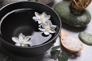 Beautiful composition with spa products and flowers on light grey table, closeup