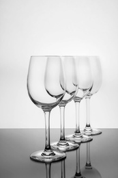 Photo of Row of empty wine glasses on white background