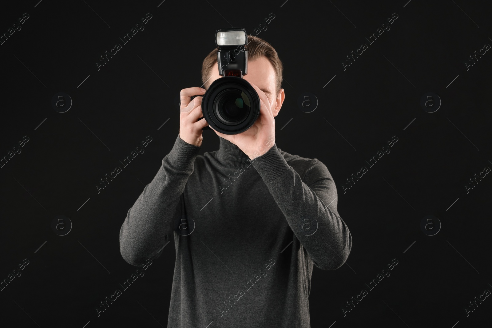 Photo of Professional photographer taking picture on black background