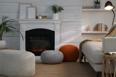 Photo of Stylish comfortable poufs near sofa in room. Home design