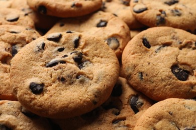 Photo of Many delicious chocolate chip cookies as background, closeup