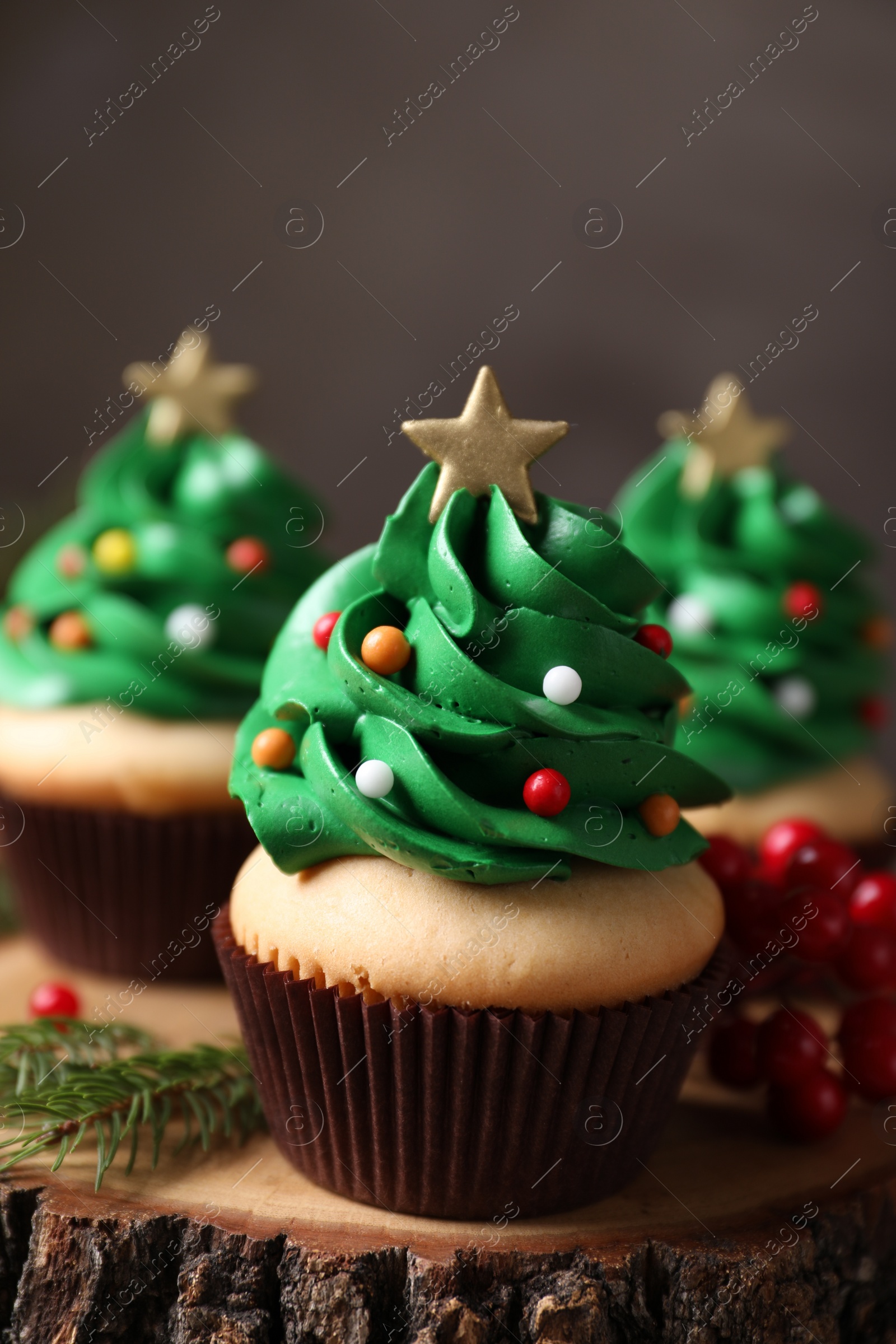 Photo of Christmas tree shaped cupcakes on wooden stand, closeup