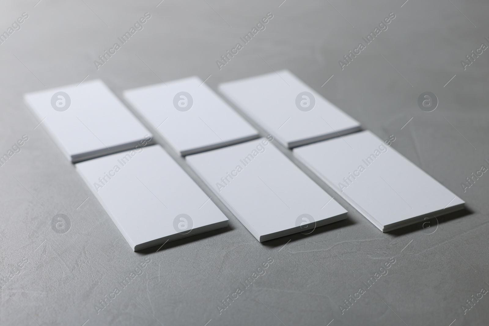 Photo of Blank business cards on light grey textured table, closeup. Mockup for design