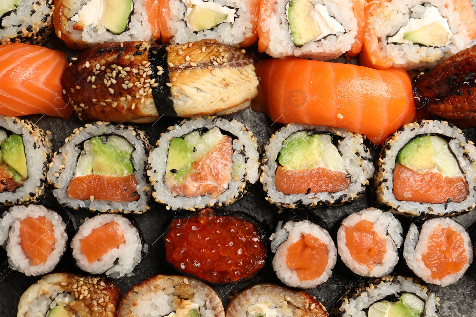 Photo of Different tasty sushi rolls as background, top view