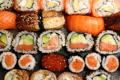 Photo of Different tasty sushi rolls as background, top view