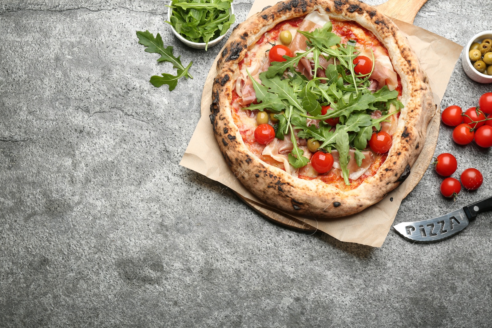 Photo of Tasty pizza with meat and arugula on grey table, flat lay. Space for text
