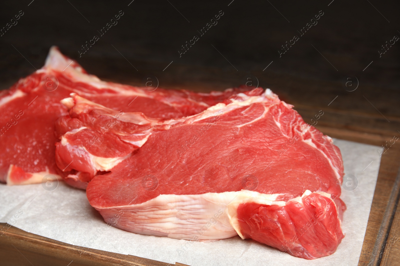 Photo of Fresh raw beef cut on wooden table, closeup