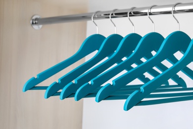 Photo of Clothes hangers on metal rail in wardrobe