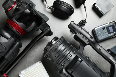 Photo of Flat lay composition with camera and video production equipment on grey stone background