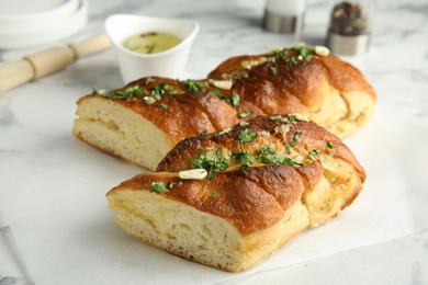 Delicious homemade garlic bread with herbs on table