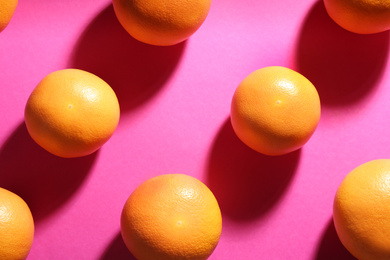 Photo of Tasty ripe grapefruits on magenta background, flat lay