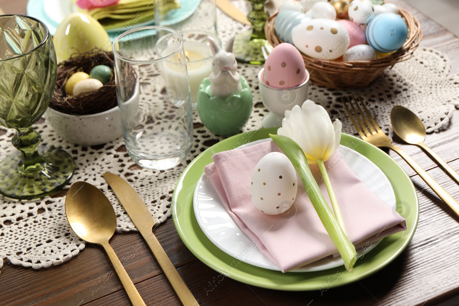 Photo of Festive table setting with painted eggs, closeup. Easter celebration