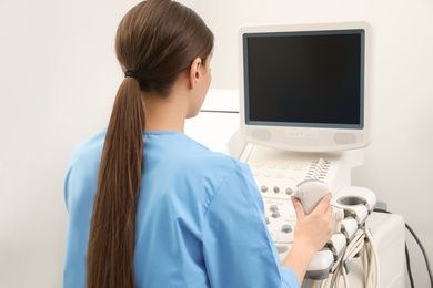 Sonographer operating modern ultrasound machine in clinic