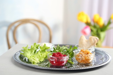 Photo of Traditional Passover (Pesach) Seder plate with symbolic meal on table indoors, space for text