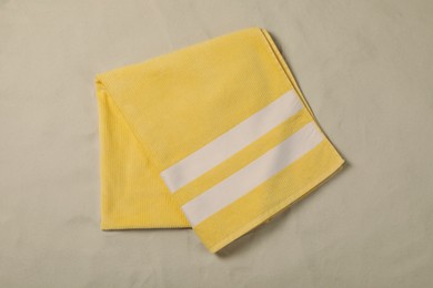 Photo of Yellow beach towel on sand, top view