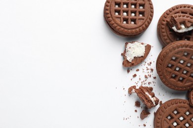 Tasty sandwich cookies with cream on white background, flat lay. Space for text