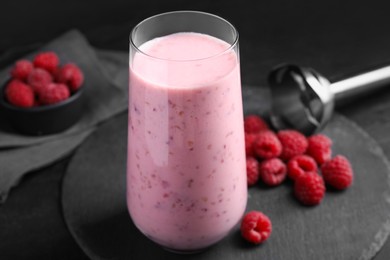 Photo of Glass of tasty raspberry smoothie on dark table, closeup