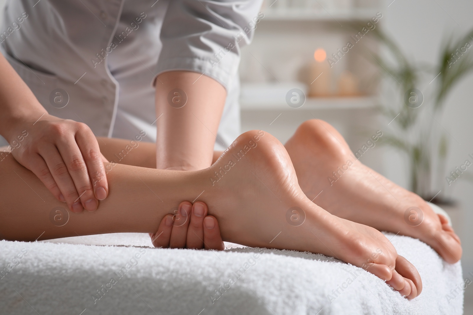 Photo of Woman receiving leg massage in spa salon, closeup