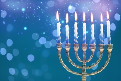 Hanukkah celebration. Menorah with burning candles on blue background with blurred lights, space for text