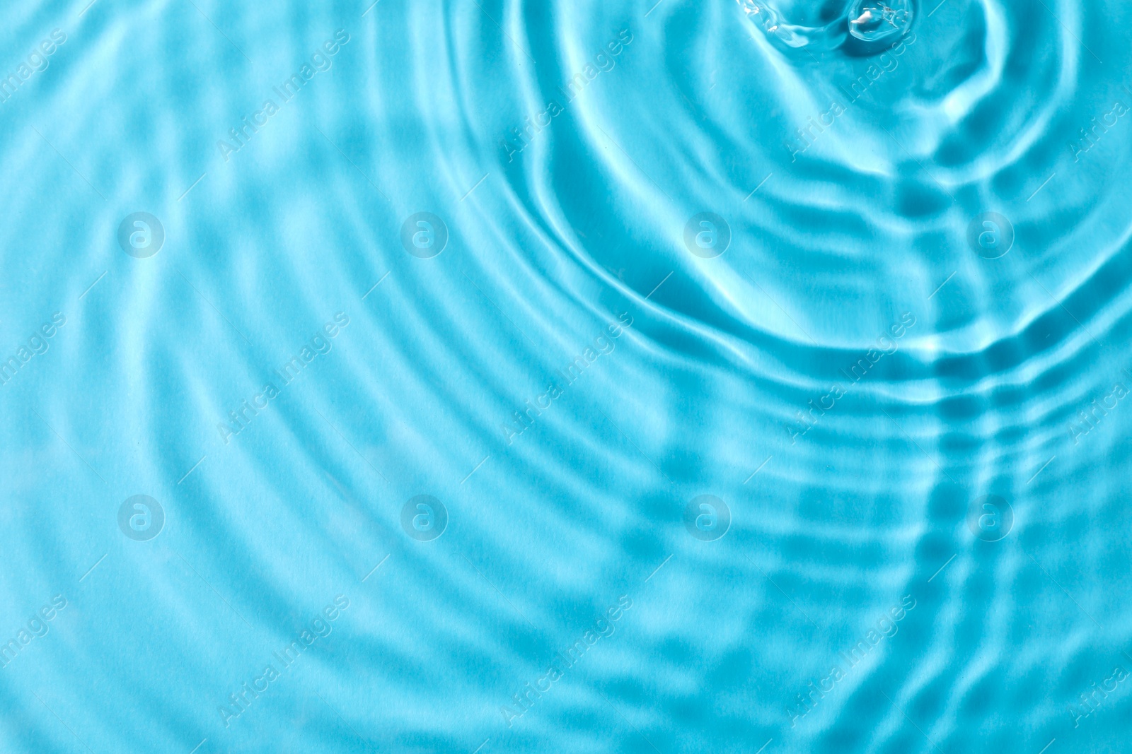 Photo of Closeup view of water with rippled surface on light blue background