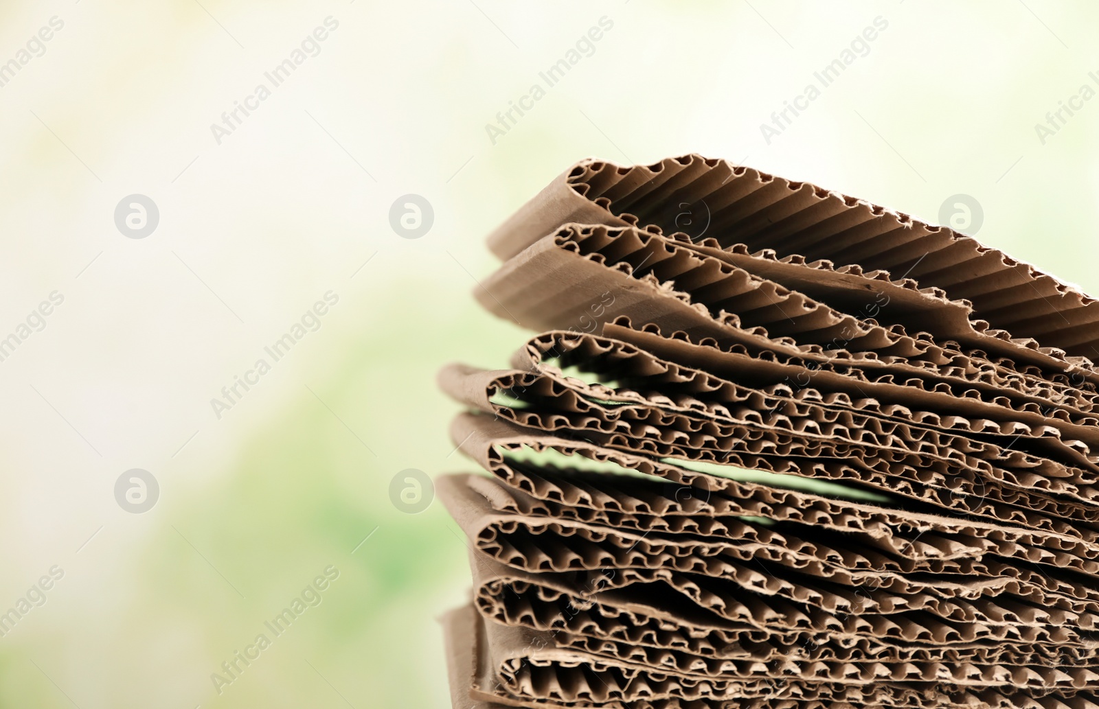 Photo of Stack of cardboard for recycling on blurred background. Space for text