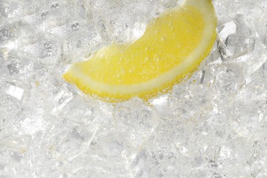 Photo of Juicy lemon slice and ice cubes in soda water on white background, closeup