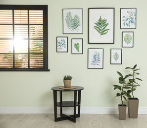 Photo of Living room interior with paintings of tropical leaves on white wall