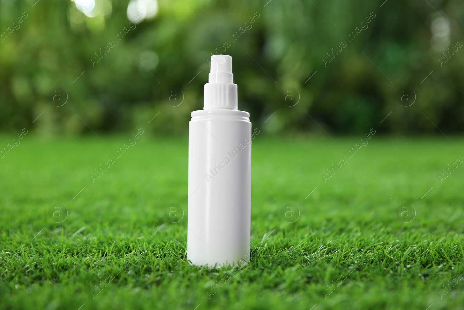 Photo of Bottle of insect repellent spray on green grass