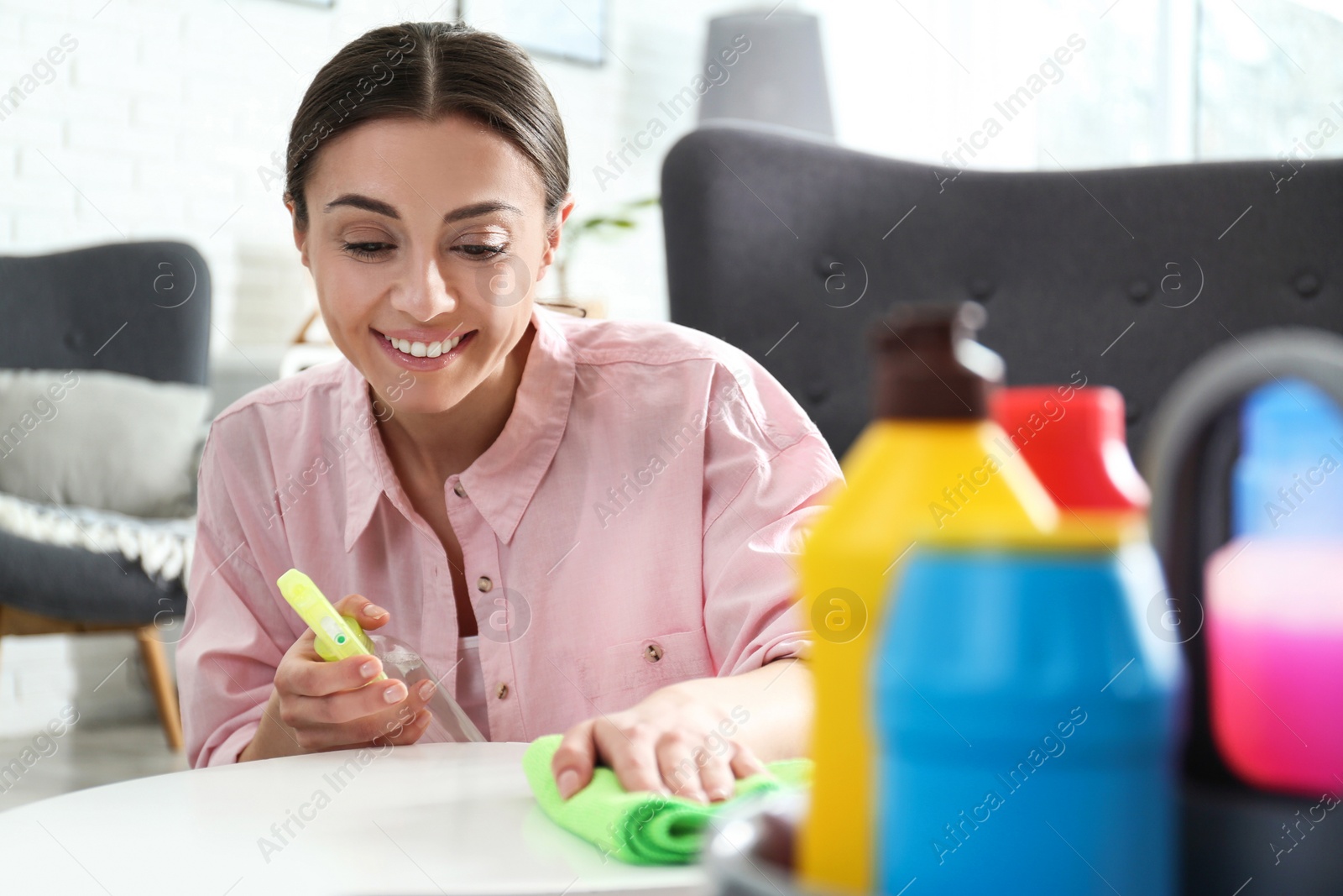 Photo of Portrait of woman cleaning table with rag in living room