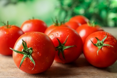 Photo of Fresh ripe tomatoes on wooden table, closeup