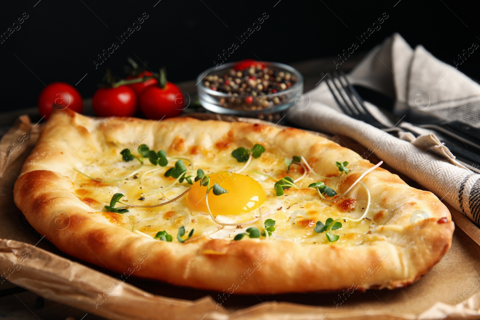 Photo of Fresh delicious Adjarian khachapuri with microgreens, closeup