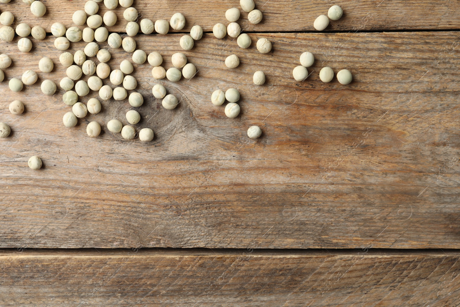 Photo of Raw dry peas and space for text on wooden background, flat lay. Vegetable seeds