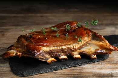 Photo of Delicious roasted ribs served on wooden table