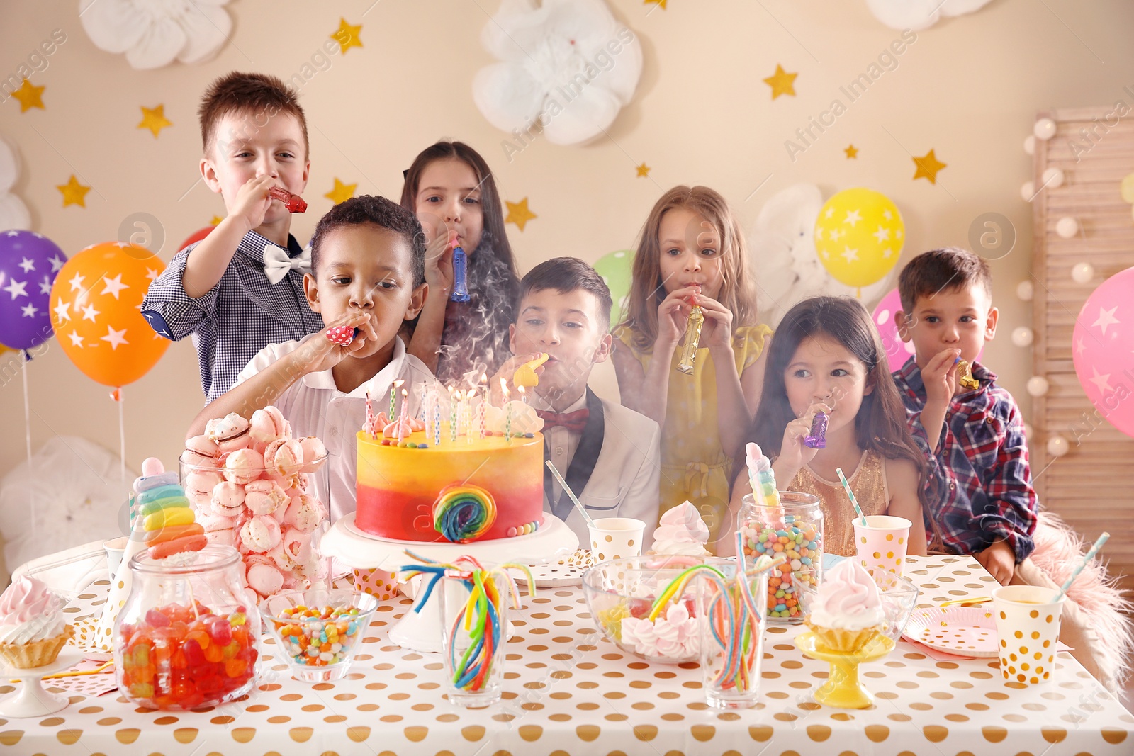 Photo of Cute children celebrating birthday at table indoors