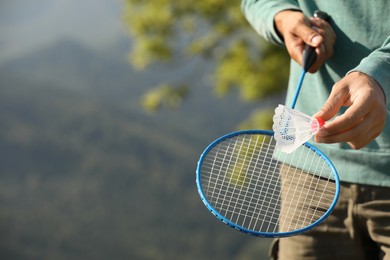 Man playing badminton outdoors on sunny day, closeup. Space for text